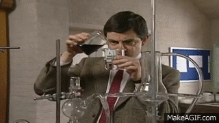 A man with a puzzled expression is experimenting in a chemistry lab, pouring liquid from a beaker into a test tube surrounded by other scientific apparatus.