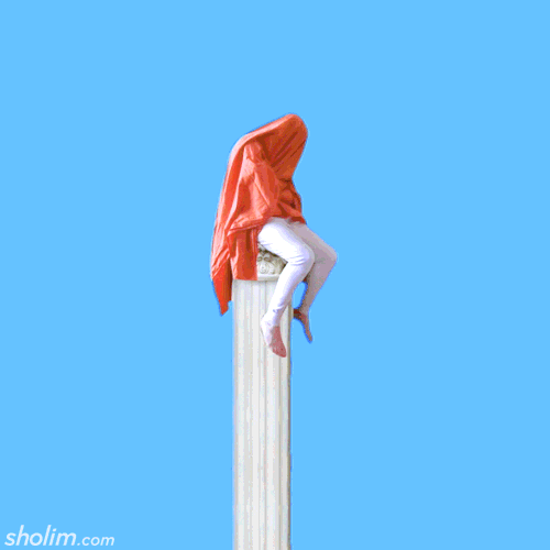 Animated image of a person sitting atop a tall, narrow column, covered by an orange fabric that flutters in the wind against a clear blue sky.