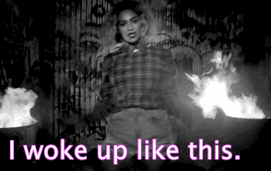 Animated gif showing a woman in a plaid shirt, confidently striding and tossing her hair, with the caption "i woke up like this" in white text at the bottom.