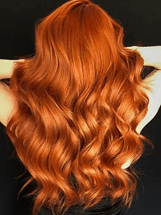 A woman with long, wavy auburn hair cascading down her back against a black background.