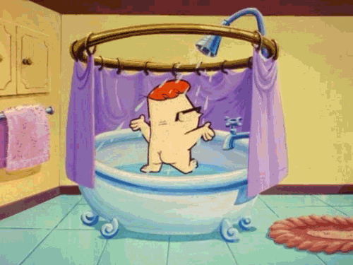 Animated gif of a cartoon character with red hair, joyfully dancing and slipping while taking a shower, surrounded by a translucent shower curtain.